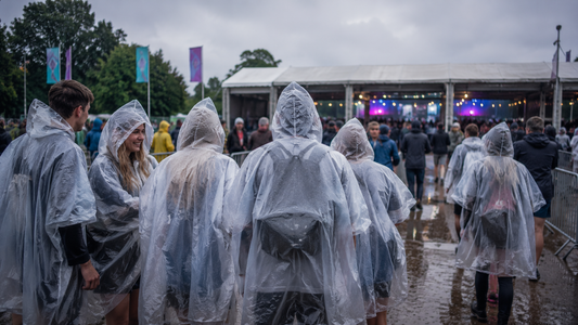 Menschen mit transparentem Regenponcho bei einem Outdoor Event als Alternative zur Regenjacke