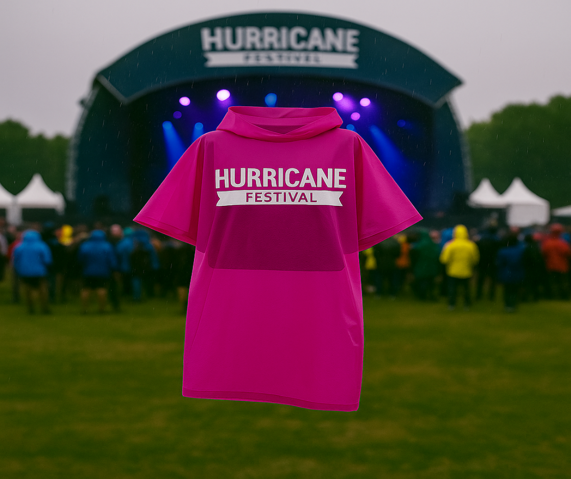 Ein magentafarbener Regenponcho mit weißem "Hurricane Festival"-Logo wird vor der Hauptbühne des Hurricane Festivals präsentiert. Im Hintergrund stehen Festivalbesucher bei Regen auf einer Wiese, während die Bühne in buntem Licht erstrahlt.